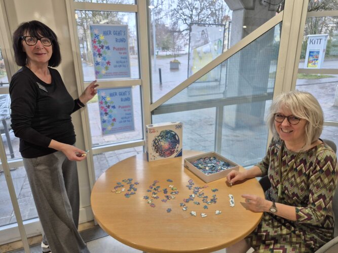 Spieletisch mit Puzzle und Bibliothkekskolleginnen